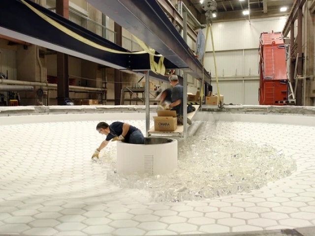 Technicians at the Richard F. Caris Mirror Lab load chunks of glass onto the honeycomb mold during fabrication of Rubin Observatory’s combined primary/tertiary mirror.
