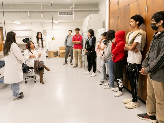 students standing and watching a presentation in an engineering lab