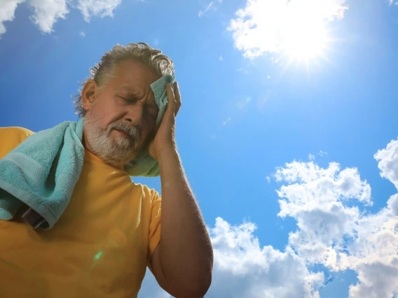 Elderly man cools himself off with a towel