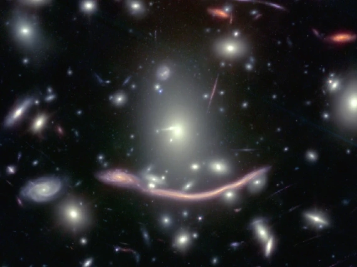 The galaxy Abell 370 appears twice in this image taken with the Hubble Space Telescope: as a normal galaxy and a drawn-out smear of light due to gravitational lensing. 