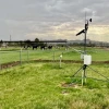 weather sensors standing on towers in a small field